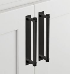 two black handles on the front of a white cabinet