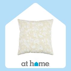 a white pillow sitting on top of a blue and white background with the at home logo below it