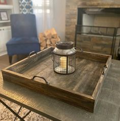 a wooden tray with a candle on top of it in front of a fire place