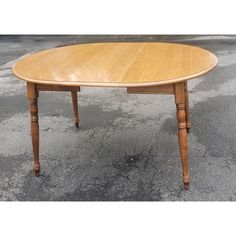 a wooden table sitting on top of a parking lot with no one around it,