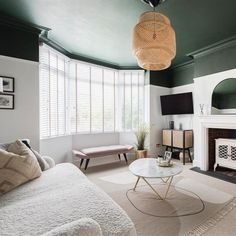 a living room filled with furniture and a flat screen tv mounted on the wall next to a fire place