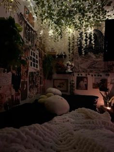 a bedroom with lights hanging from the ceiling and pictures on the wall above it, along with an unmade bed