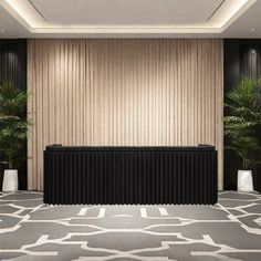 an empty room with two planters and a large black table in the middle of it