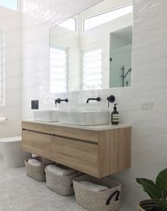 a white bathroom with two sinks and mirrors