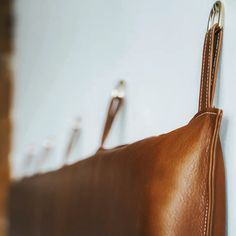 a brown leather purse hanging on the wall