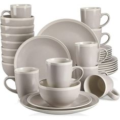 white dishes and cups are stacked on top of each other in front of a white background