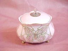 a white box with a butterfly design on the front and bottom, sitting on a pink surface