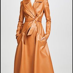 Brand New! A.W.A.K.E. Mode Faux-Leather Trench Coat Marmalade Brown Faux-Leather Trench Coat From A.W.A.K.E Mode Featuring A Pointed Collar, A Front Button Fastening, Long Sleeves, A Belted Waist, Side Seam Pockets, An Asymmetric Hem And A Mid-Length. Made In United Kingdom Composition Polyester 100% Designer Brown Belted Outerwear, Luxury Brown Belted Outerwear, Designer Belted Leather Jacket For Fall, Luxury Brown Long Coat, Designer Leather Spring Outerwear, Designer Leather Outerwear For Spring, Luxury Leather Belted Outerwear, Elegant Brown Leather Jacket For Fall, Designer Leather Jacket For Office, Fall