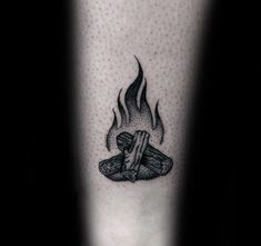 a black and white photo of a foot with a burning log tattoo on the leg