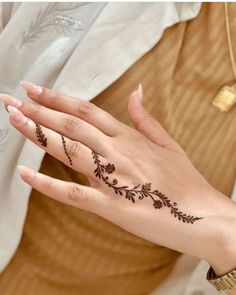 a woman's hand with henna tattoos on it