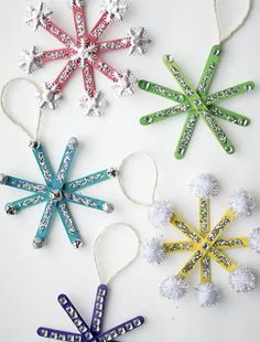 four snowflake ornaments are hanging from string