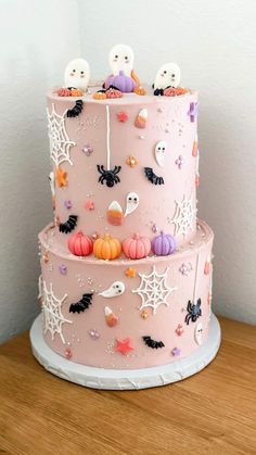 a three layer cake decorated with spooky decorations and ghost faces on it's sides