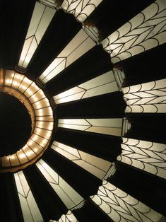 a circular light fixture in the middle of a room with stained glass panels on it