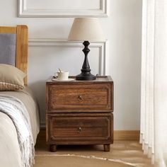 a nightstand with a lamp on top of it next to a bed and a window