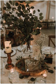 the table is set with candles, flowers and an old sign that says once on it