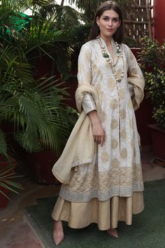 Featuring a beige kurta in pure banarsi muga silk base with gota patti embroidery. It is paired with matching sharara pants and a dupatta.  FIT: Fitted at bust and waist. COMPOSITION: Pure banarsi muga silk. CARE: Dry clean only. Sabyasachi Sharara Outfit, Latest Suit Designs 2024, Banarasi Kurti Design, Banarsi Kurti Designs Latest, Sharara Ideas, Sharara Outfits, Gota Patti Embroidery, Kurti Ideas, Beige Kurta