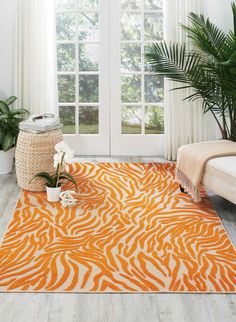 an orange and white rug with zebra print on the floor in front of a window