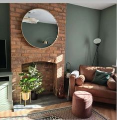 a living room with a couch, fireplace and mirror on the wall in front of it