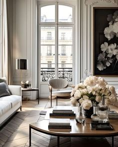 a living room filled with furniture and a large painting above the coffee table in front of a window