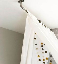 a white curtain with gold polka dots hanging from it