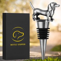 a bottle stopper with a dog figurine on it next to a box