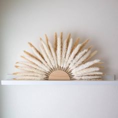 a white shelf topped with lots of dry grass on top of it's sides