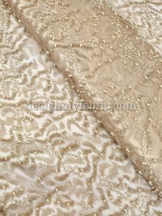 the fabric is beige and has gold sequins on it