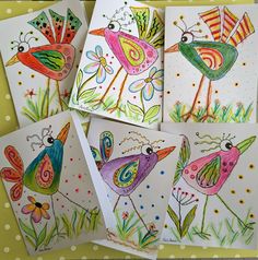 four cards with colorful birds on them sitting in front of polka dot dots and green grass