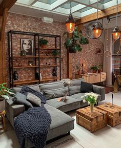 a living room filled with lots of furniture next to a brick wall covered in potted plants