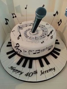 a birthday cake decorated with musical notes and a microphone