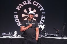 a man standing in front of a dj set on top of a stage with microphones