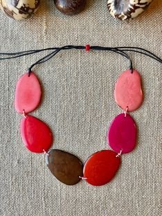 Handmade in Ecuador Necklace Length: Adjustable Length 14 -31 Inches Due to this item being handmade and the nature of the Tagua Nut the size and the color may vary from piece to piece Adjustable Red Nature-inspired Jewelry, Multicolor Jewelry With Adjustable Cord, Adjustable Pink Resin Necklace, Adjustable Multicolor Nature-inspired Jewelry, Handmade Red Nature-inspired Necklace, Pink Bohemian Resin Jewelry, Bohemian Pink Resin Jewelry, Adjustable Bohemian Resin Jewelry, Handmade Pink Nature-inspired Necklace