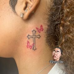 a woman with a cross tattoo on her neck and behind her ear is a small butterfly