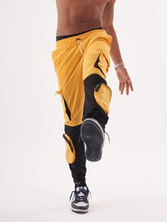 Double-color yellow and black joggers with four functional cargo pockets on the knees and elastic ankles. FEATURES Slim Fit Made up of 95% Cotton and 5% Elastane Jogger comfort Drawstring waist SIZE GUIDE Model's height and weight: 6"1 feet & 180 lbs. (185 cm & 82 kg ) Model wears size: L Urban Joggers With Cargo Pockets For Sports, Sporty Cargo Style Joggers For Streetwear, Nylon Cargo Joggers For Athleisure, Nylon Cargo Pocket Joggers For Athleisure, Nylon Athleisure Joggers With Cargo Pockets, Athleisure Cargo Joggers For Streetwear, Nylon Joggers For Streetwear Style, Sportswear Joggers With Cargo Pockets For Streetwear, Sporty Streetwear Parachute Pants With Cargo Pockets