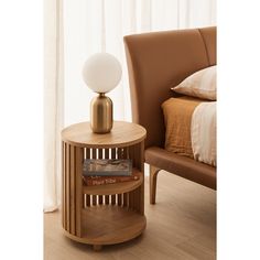 a wooden table with a lamp on top of it next to a chair and bed