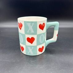 a cup with hearts on it sitting on a table