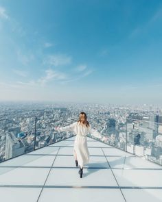 a woman standing on top of a tall building