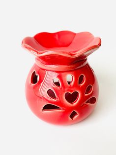 a red vase sitting on top of a white table