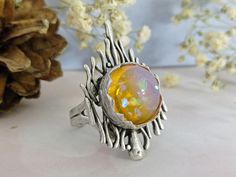 A large decorative and bold silver ring featuring a yellow opal glass cabochon. This ring is unusual in design and makes a big statement. Made from Zamak, the ring is very hard wearing and durable. Zamak is a brass alloy which we dip twice in 925 silver. Being nickel and lead free the ring is hypoallergenic and also it won't turn your finger green! The ring is adjustable to fit Antique silver plated Nickel and lead free Weight: 35 gm Sent in a luxury box as standard, ready to gift if required. H Unique Handmade Iridescent Opal Ring, Handmade Unique Silver Opal Ring, Unique Handmade Silver Opal Ring, Handcrafted Round Opal Ring, Handmade Unique Opal Ring, Unique Handmade Opal Ring, Unique Handmade Round Opal Ring, Unique Yellow Jewelry Ring, Unique Yellow Ring Jewelry