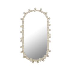 an oval mirror with white balls on the edges and a light wood frame, in front of a white background