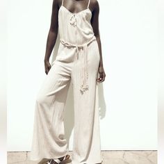 Brand New With Tag Size M Zara Sold Out Style!!! Cream Wide Leg Flowy Jumpsuit With Macrame Belt Cute Comfy And Stylish Chic Beige Jumpsuits And Rompers For Beach, Chic Beige Jumpsuit For The Beach, Beige Jumpsuits And Rompers For Beach Season, Beige Beach Jumpsuits And Rompers For Beach Season, Chic Cream Jumpsuits And Rompers For Vacation, Elegant Beige Jumpsuits And Rompers For Loungewear, Zara Summer Jumpsuits And Rompers For Beach, Zara Summer Beach Jumpsuits And Rompers, Zara Summer Beach Jumpsuit