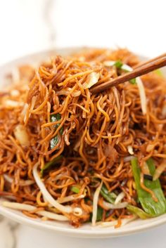 a white plate topped with noodles and chopsticks