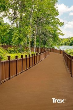 a long wooden bridge with trees and water in the background