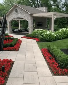 an outdoor patio with landscaping and flowers in the foreground, next to a gazebo