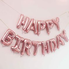 two pink happy birthday balloons hanging on a string