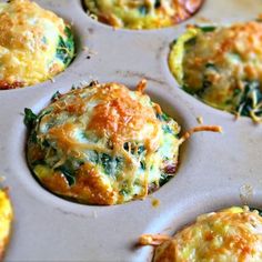 several muffins with cheese and spinach in a muffin tin