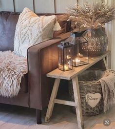 a living room with a brown couch and some candles