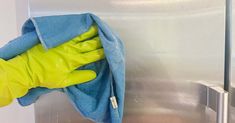 a pair of yellow rubber gloves and blue towel hanging on a wall next to a stainless steel door