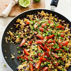 a skillet filled with rice, beans and vegetables