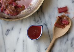 a wooden spoon sitting on top of a counter next to a bowl filled with food